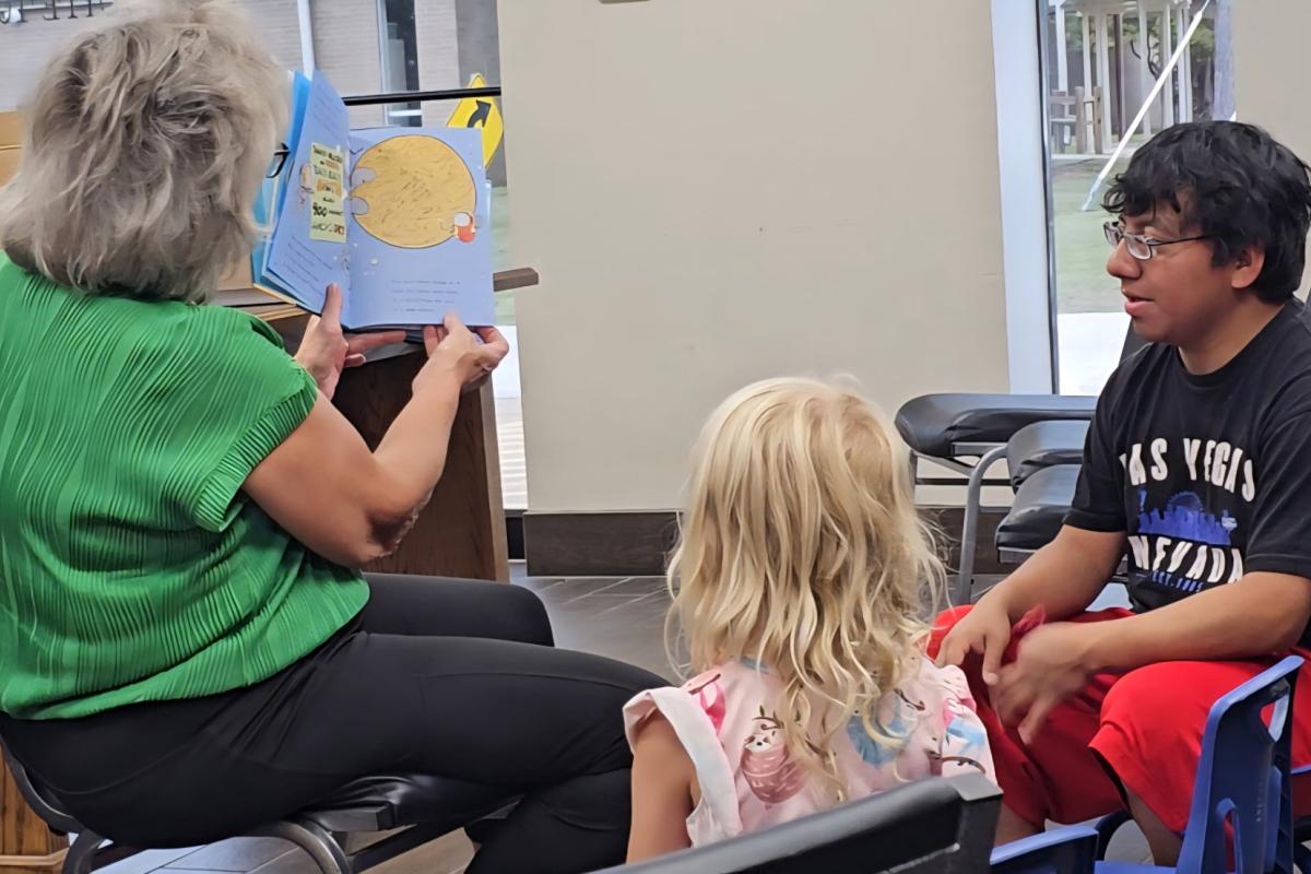 Mrs. Beth Imm is reading a favorite selection.  Each year they join our programs to volunteer to work with area children. 